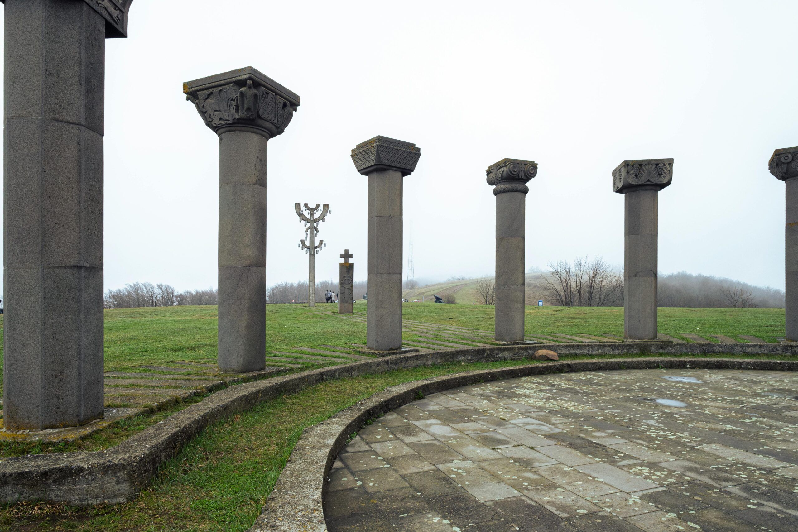 Stone columns in Mtskheta-Mtianeti, Georgia, under a cloudy sky, capturing the ancient architecture.
